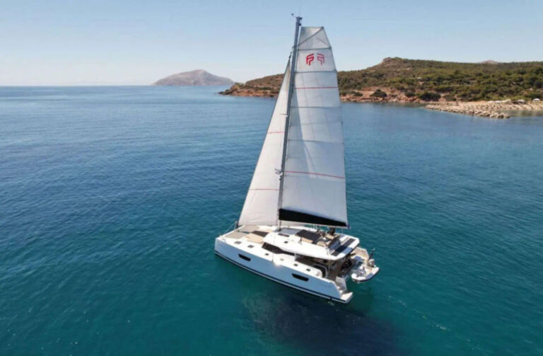 Aerial view of the Fountaine Pajot 47 catamaran sailing in the clear blue waters of Mykonos, a unique adventure by Events on Board.