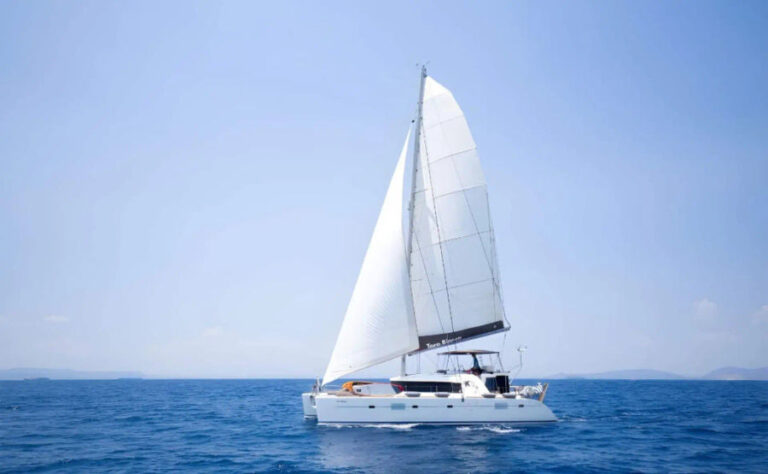 The Lagoon 500 catamaran sailing smoothly through the azure waters of the Aegean Sea in Mykonos under clear blue skies.