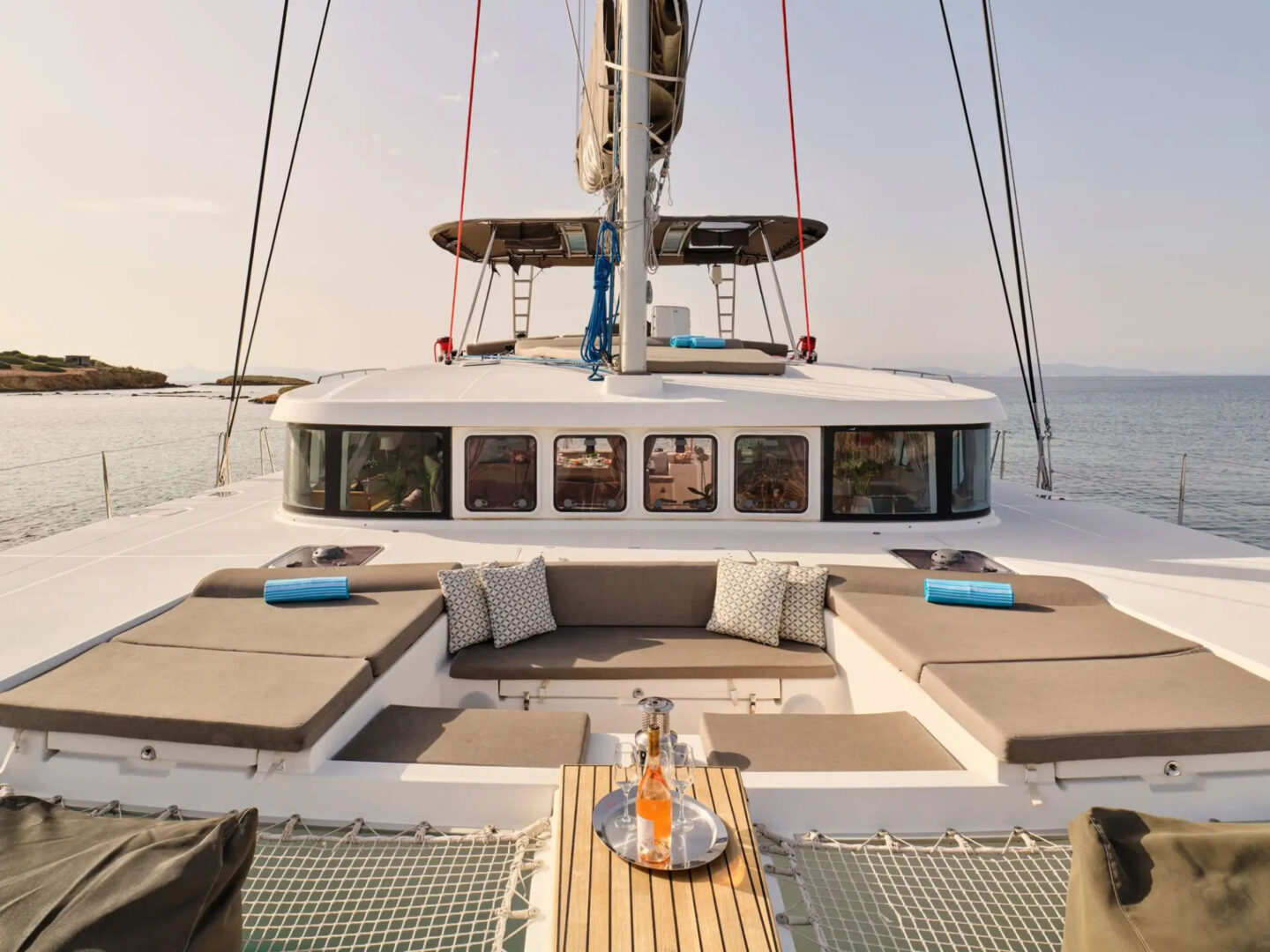 The expansive deck of the Lagoon 500 catamaran in Mykonos featuring comfortable lounge areas and stunning ocean views.