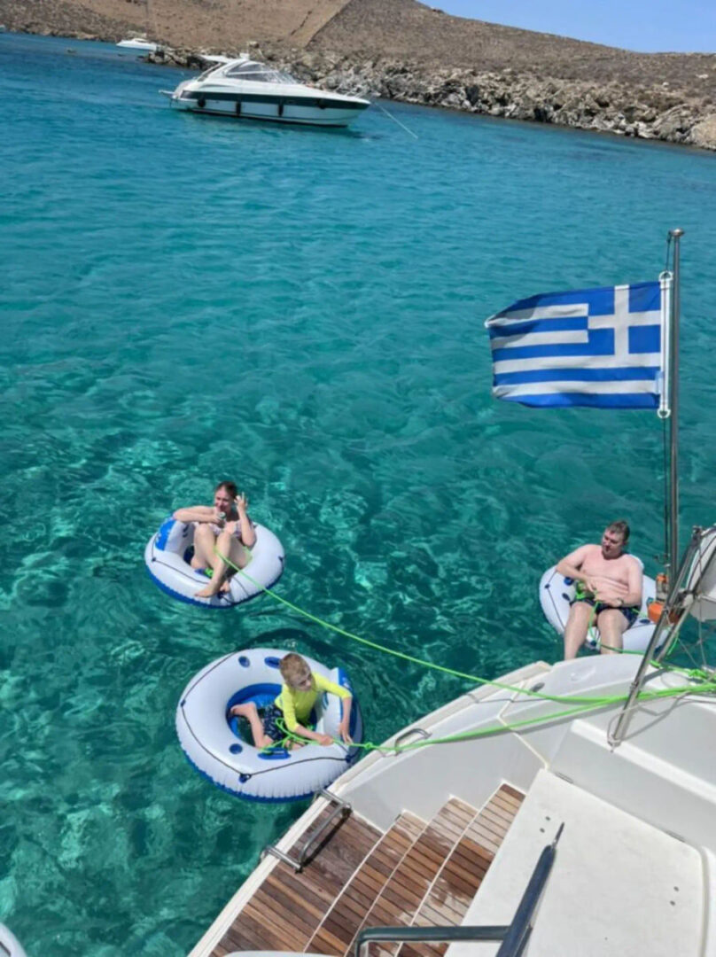 Guests having fun in the water, floating with inflatables near the Lagoon 420 Catamaran during a bachelorette cruise with Events on Board.